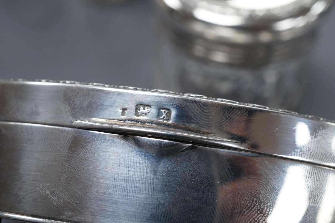 A George V oval silver trinket box, Adie Bros. Birmingham, 1922, 10.8cm, together with a silver compact, four assorted silver mounted toilet jars and a silver mounted hair brush.